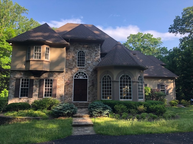 exterior of a residential home that has a stucco exterior with stone accents