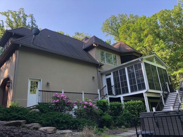 back exterior of a large home with an enclosed porch