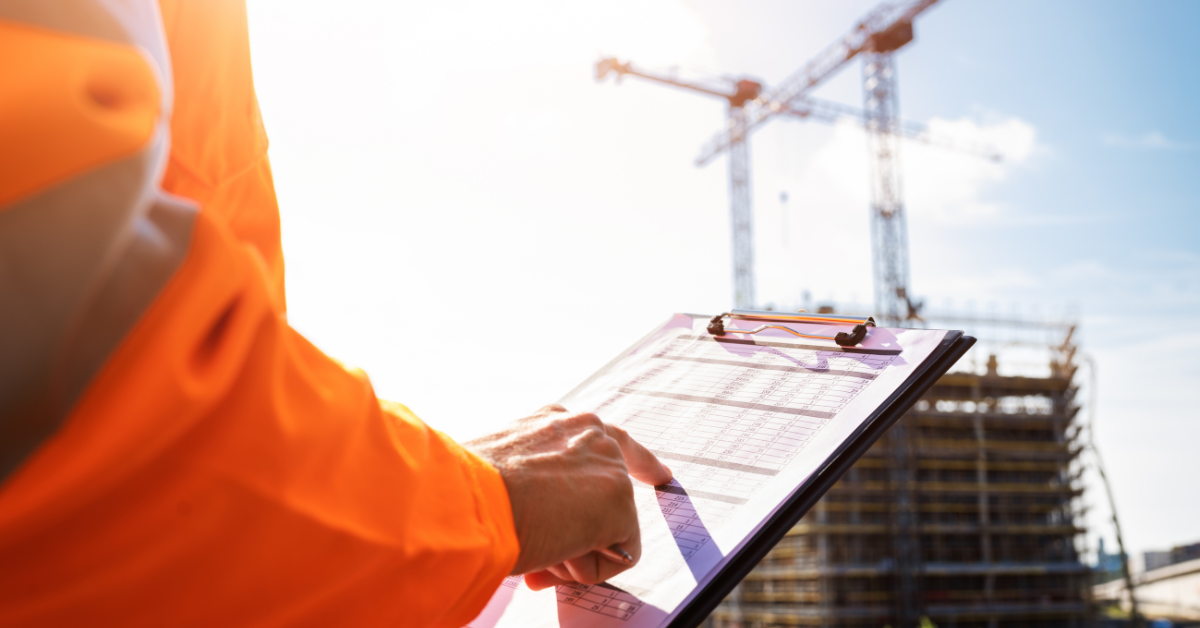Construction worker holding a clipboard at a job site