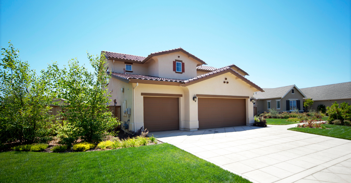 A large stucco house on a summer day.